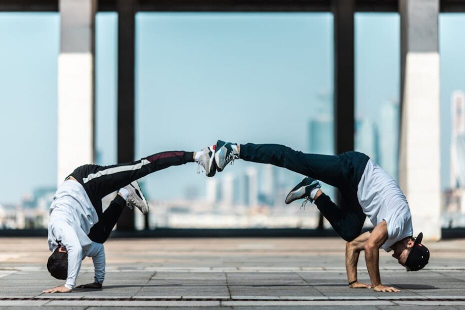 Two breakdancers showcasing impressive acrobatic skills in a modern urban setting, displaying balance and motion.